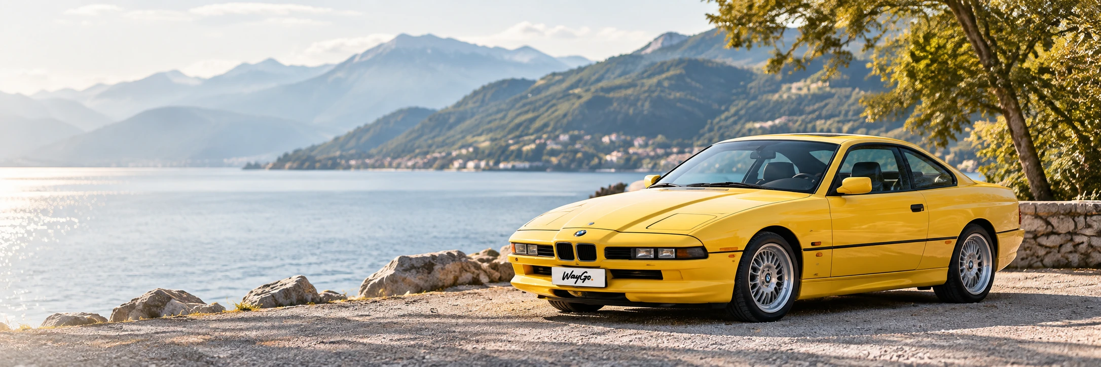 BMW 840Ci galben, întreg, pe malul unui lac de munte